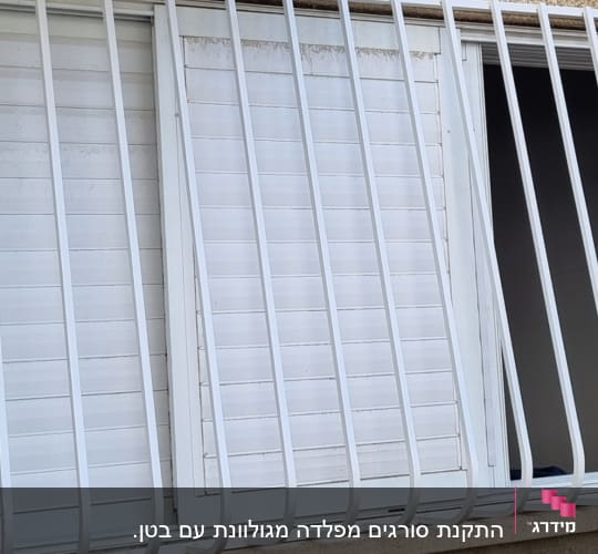 חלון עם סורגים לבנים פתוחים חלקית